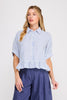 Woman wearing a blue and white striped shirt with ruffled sleeves on a plain background