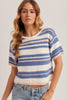 Woman wearing a striped short-sleeve sweater against a plain background