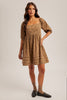 Woman wearing a patterned dress on a plain background
