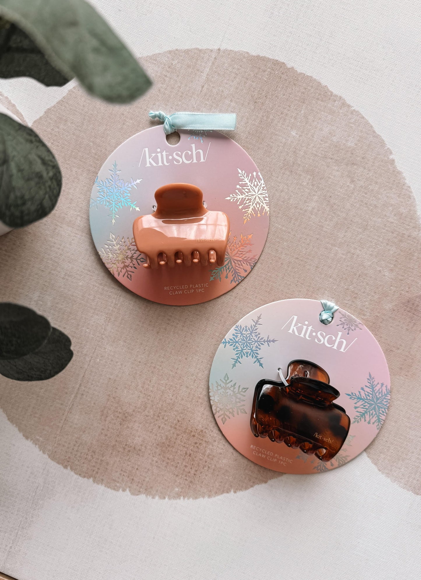 Two hair clips on 'kitsch' branded cards with a beige fabric background