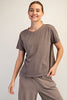 Woman wearing a brown t-shirt and pants on a plain background