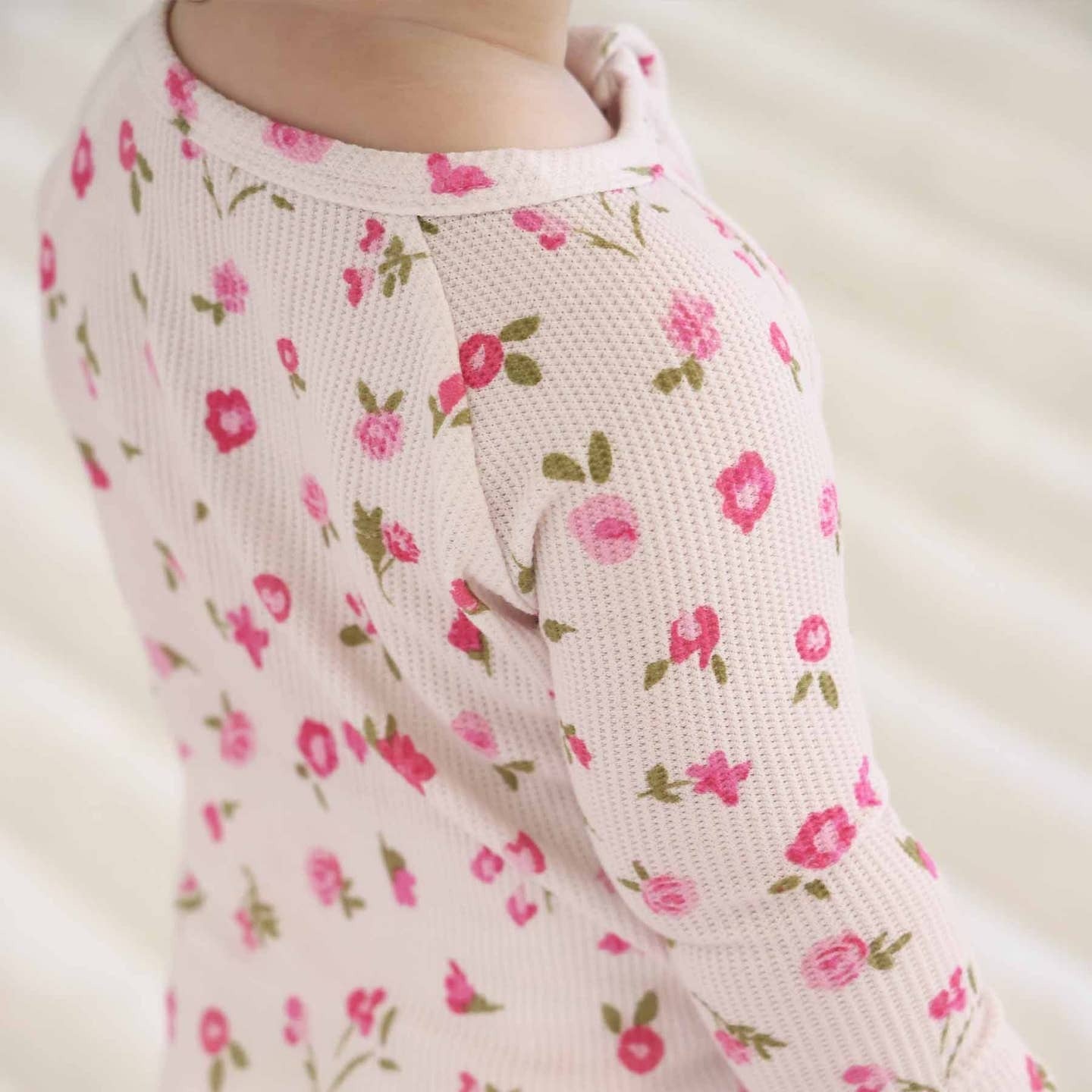 Close-up of a pink floral-patterned sweater on a blurred background