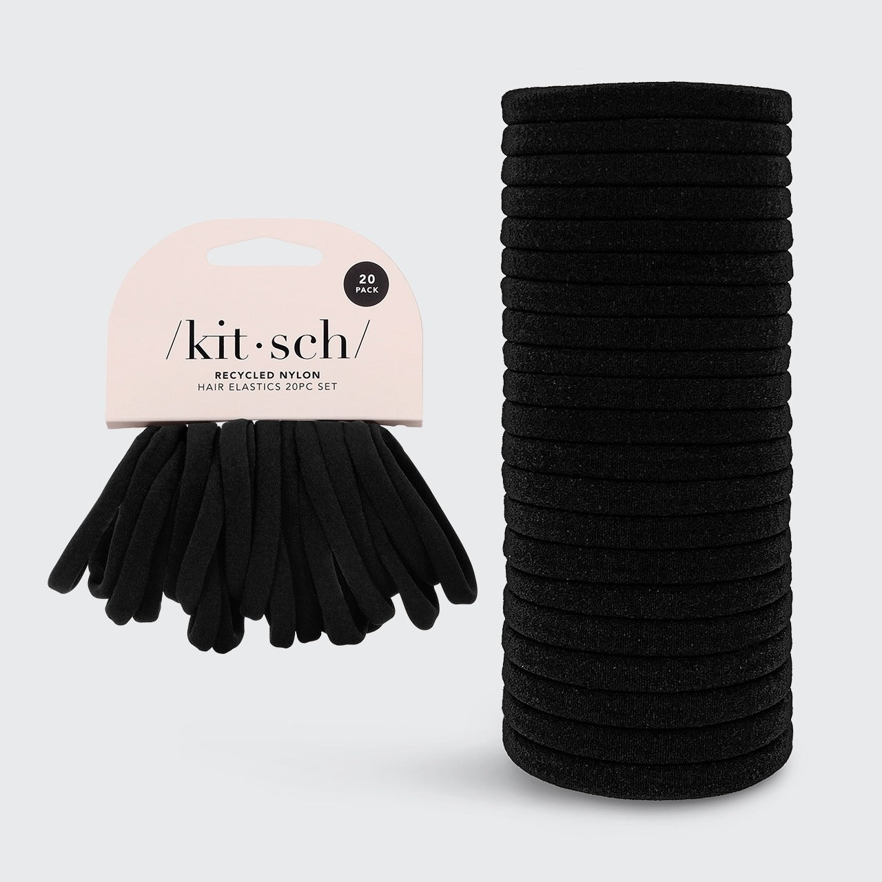 Stack of black hair ties with a 'kitsch' branded package on a light gray background