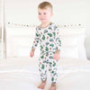 Child wearing a pajama set with green truck pattern on a white background