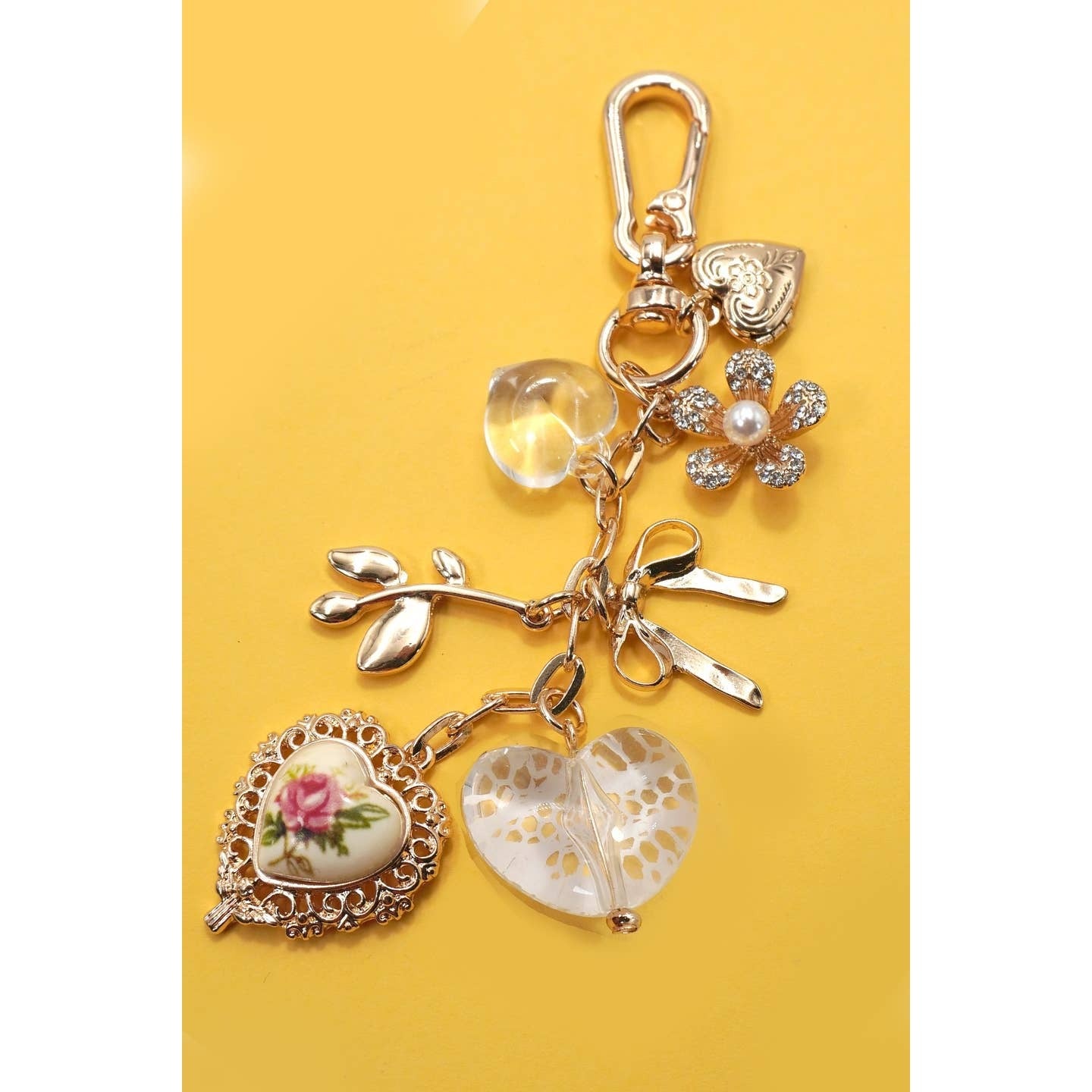 Decorative keychain with heart-shaped charms on a yellow background