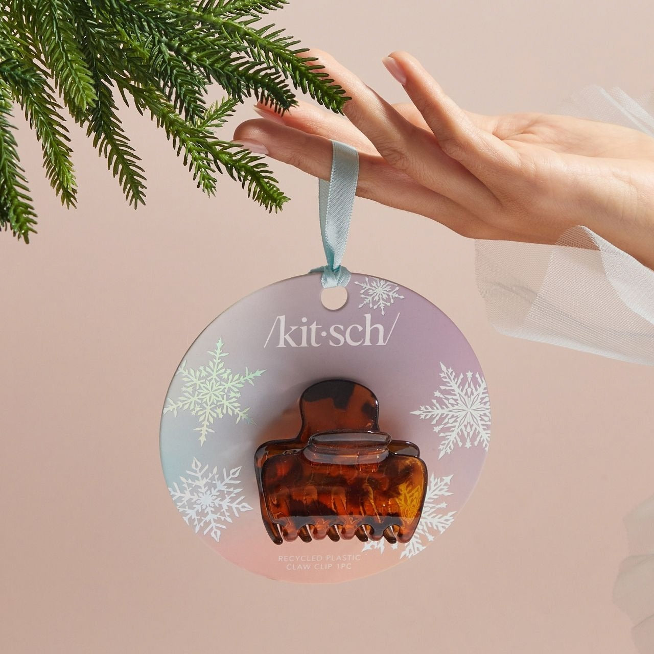 Brown hair clip ornament with 'kit-sch' branding on a pink background