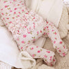 Baby legs wearing floral tights on a soft textured surface