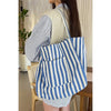 Person wearing a blue and white striped bag indoors
