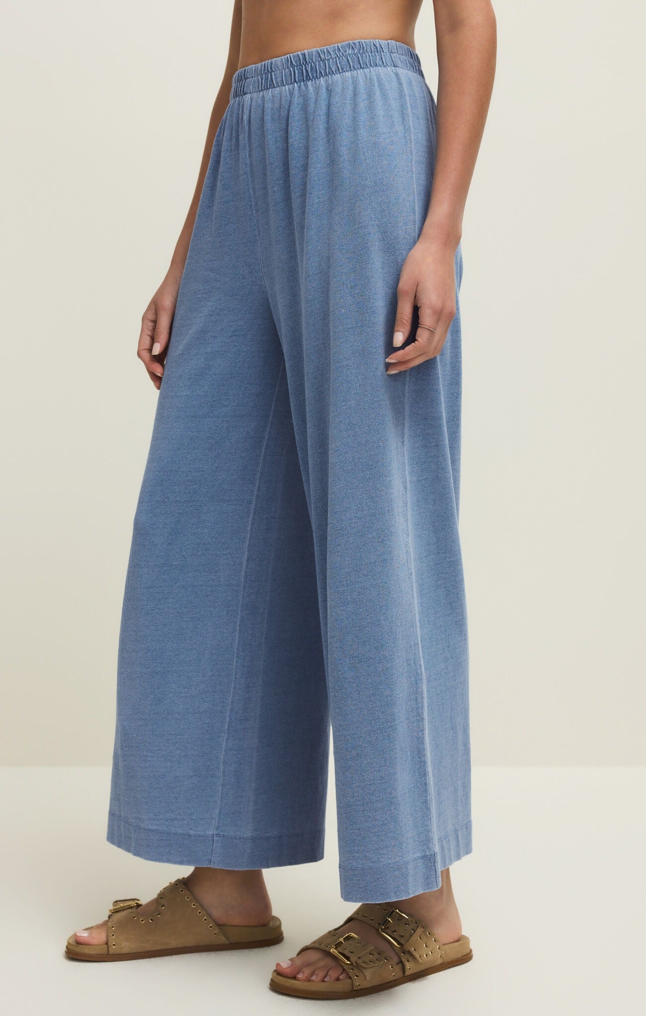 Person wearing blue wide-leg pants on a plain background