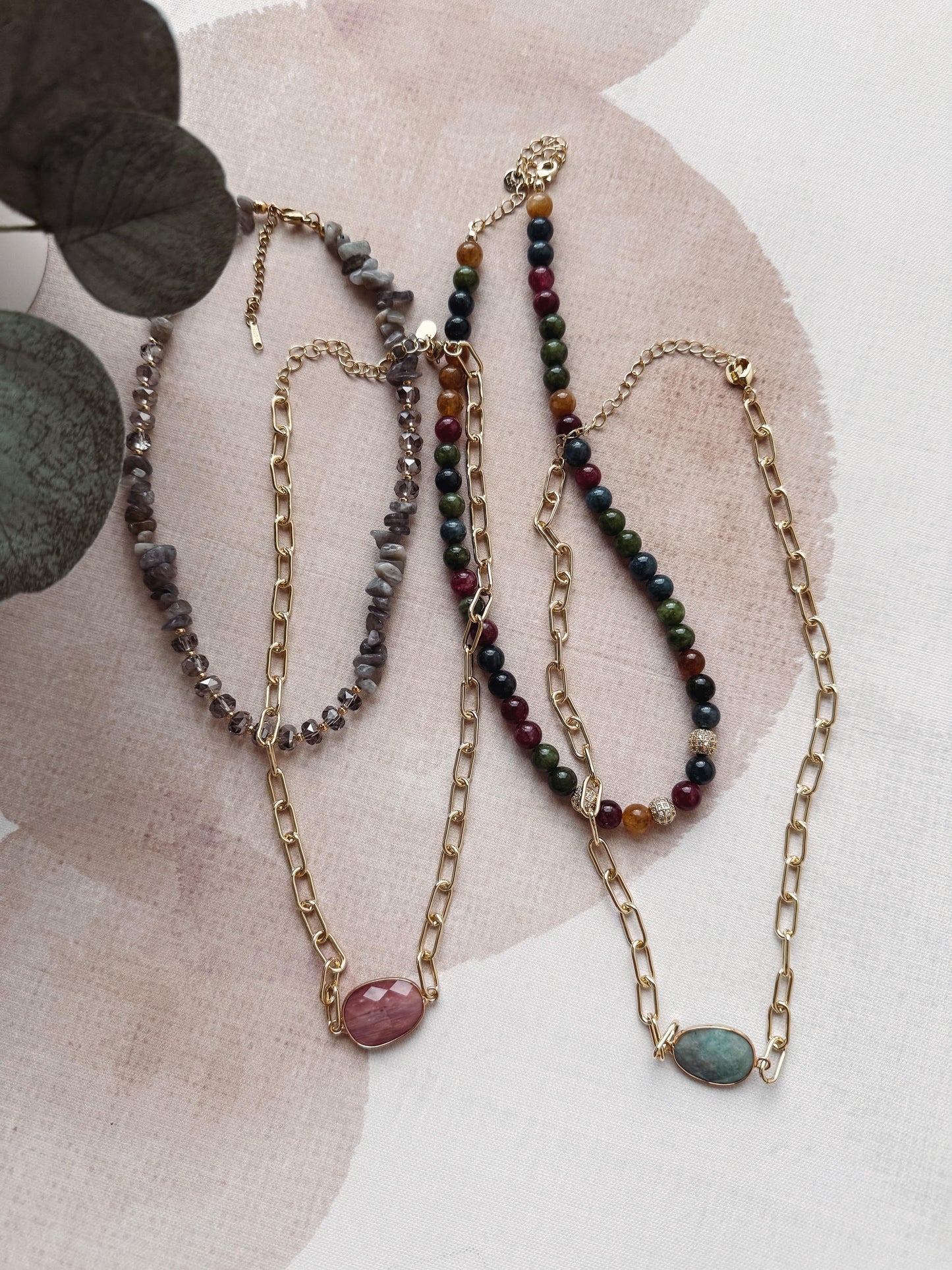 Three beaded necklaces on a textured surface