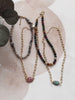 Three beaded necklaces on a textured surface