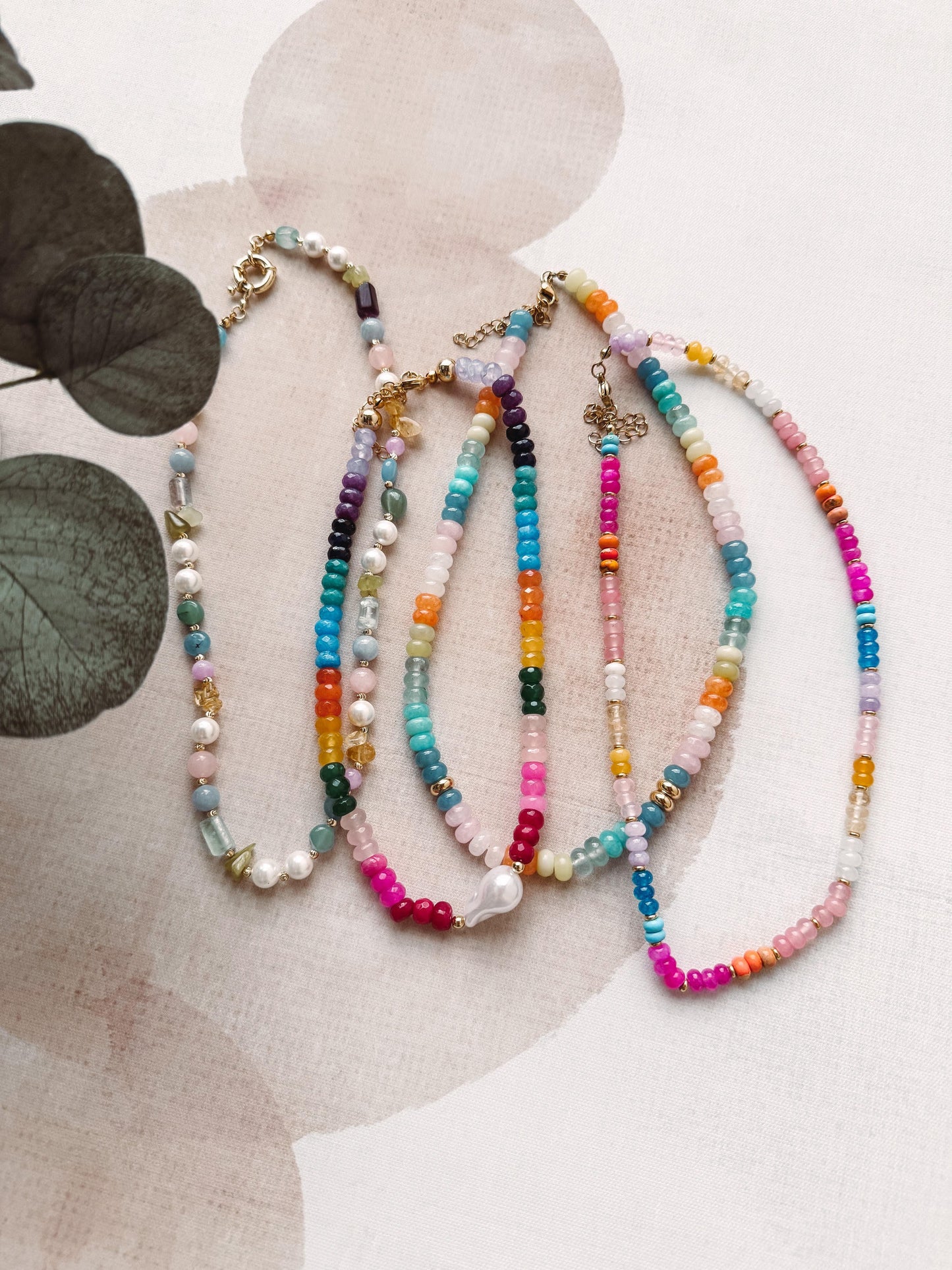 Colorful beaded necklaces on a light background