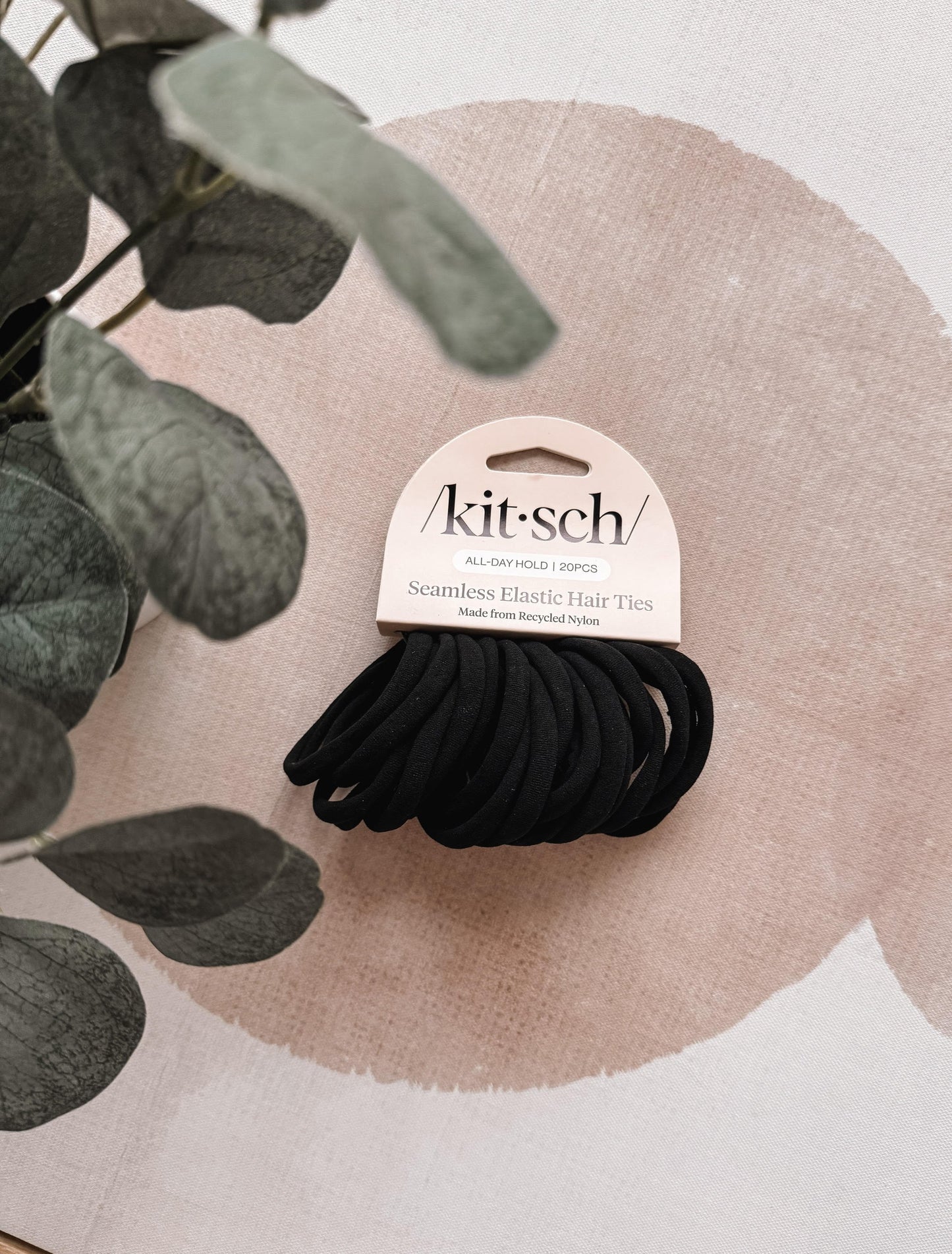 Pack of black hair ties with 'kit-sch' branding on a decorative background