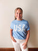 Person wearing a blue t-shirt with 'USA' printed on it against a plain background