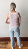 Person wearing a striped tank top and light blue jeans from the back.