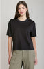 Person wearing a black t-shirt and green pants on a plain background