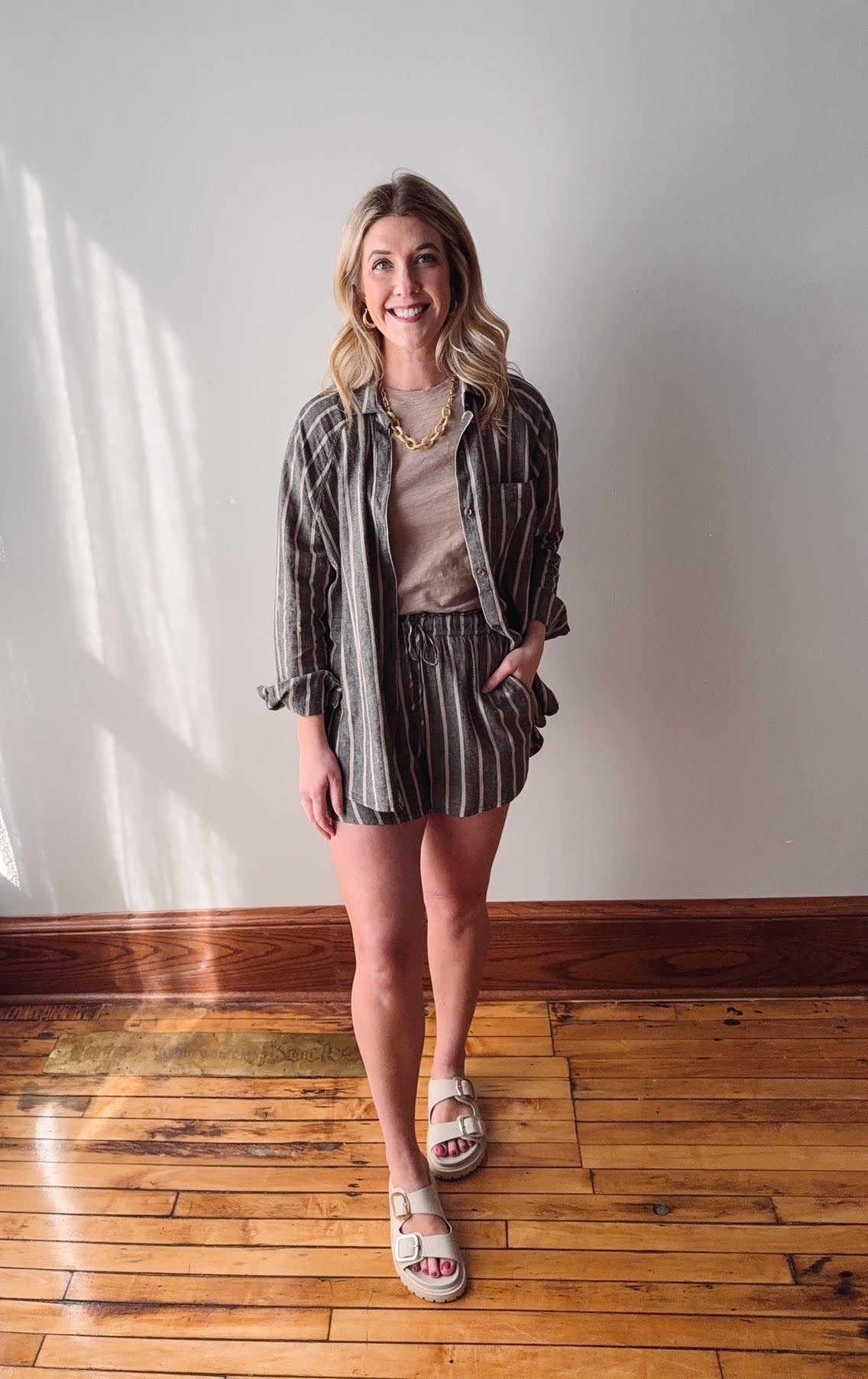 Woman standing in a room with wooden flooring and white walls