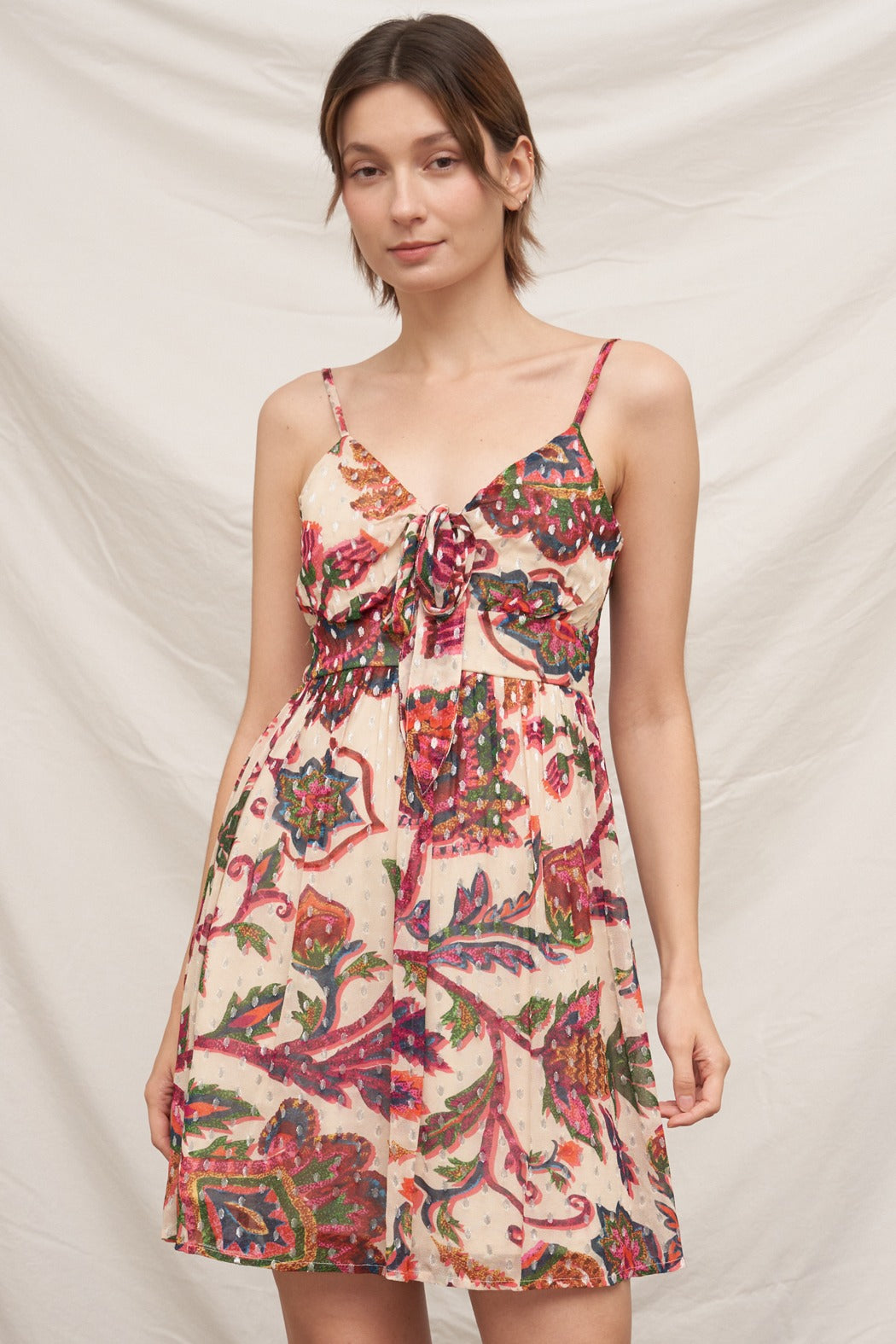 Woman wearing a floral dress against a plain background