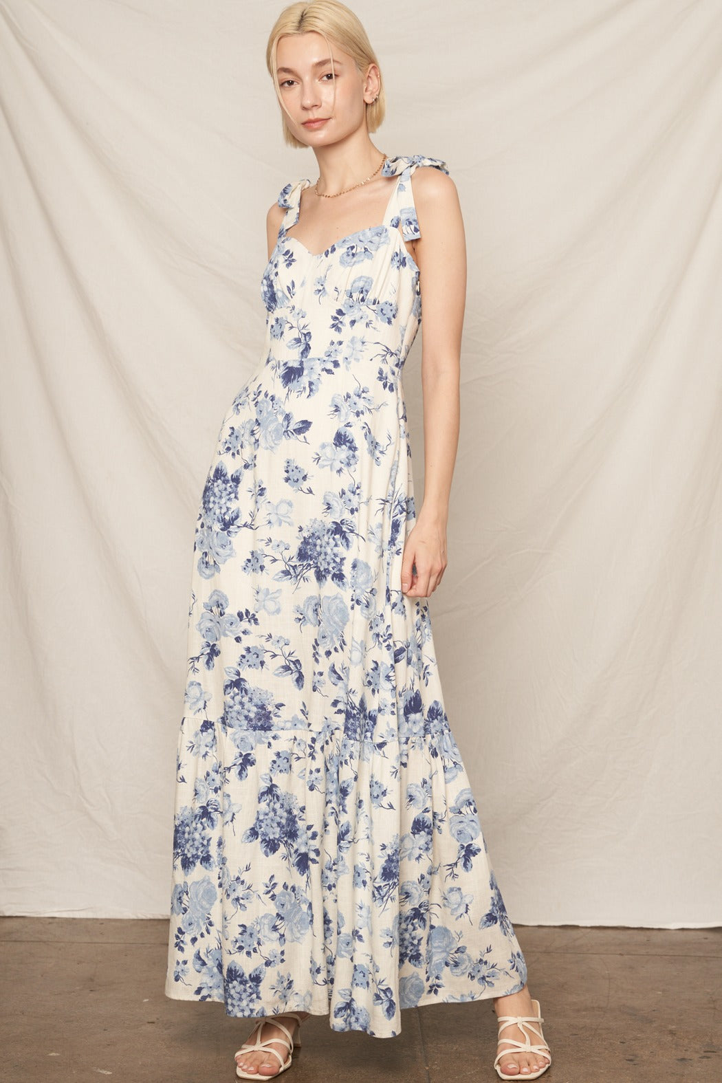 Woman wearing a floral dress against a plain background
