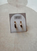 Set of earrings on a card with 'Urban Threads' branding on a textured beige background