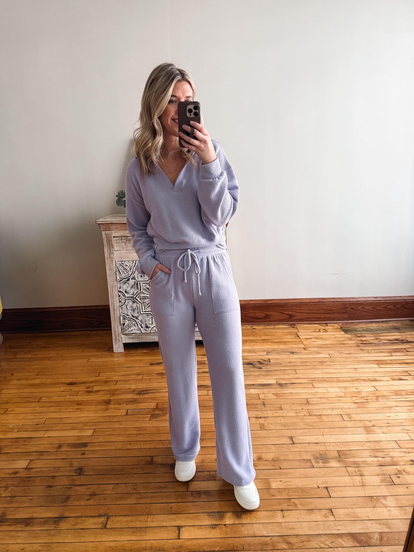 Person wearing a light purple loungewear set taking a mirror selfie.