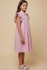 Young girl wearing a pink and white striped dress against a beige background