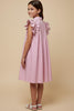 Young girl wearing a pink and white striped dress with ruffled sleeves on a beige background