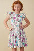 Young girl wearing a floral dress against a beige background
