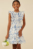 Young girl wearing a blue floral dress against a beige background
