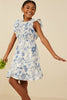 Young girl wearing a blue floral dress against a beige background