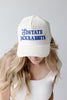 A woman wearing a white ribbed baseball cap with blue embroidered text reading 'SDSTATE JACKRABbits' on the front, shown against a light gray studio background.