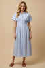 Woman wearing a light blue striped dress against a beige background