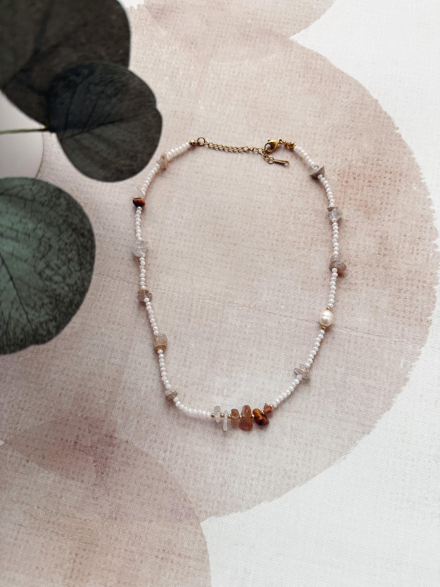 Necklace with small beads on a beige fabric background