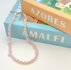 Necklace on a stack of books with 'Azores' and 'Amalfi' text
