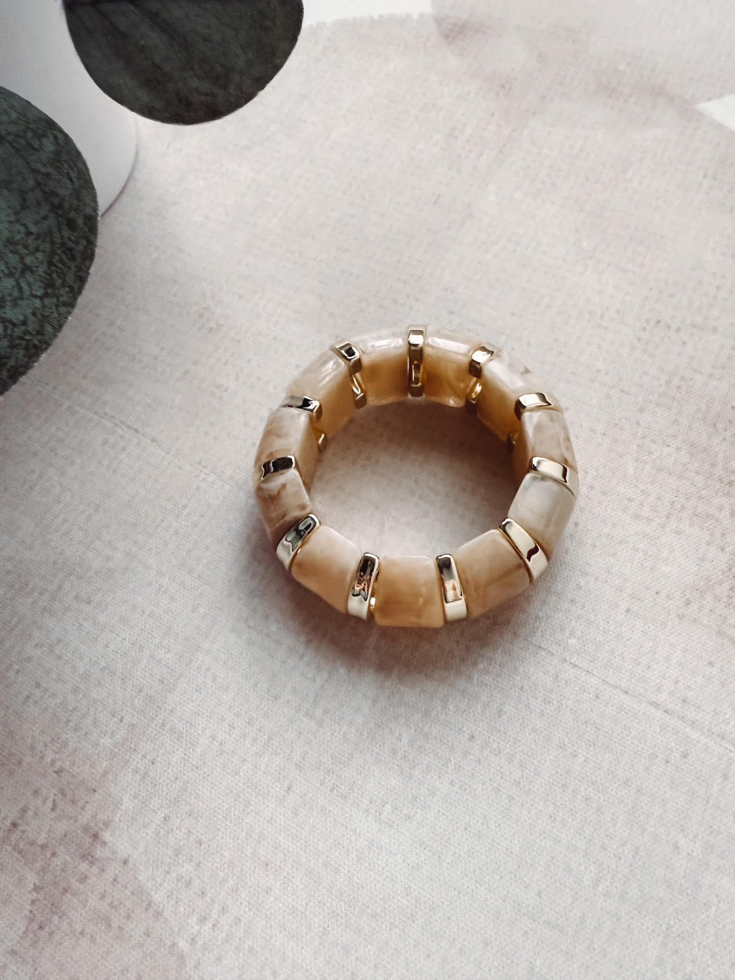 Beige beaded ring on a textured surface