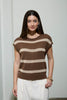 Woman wearing a brown and beige striped sweater against a plain background