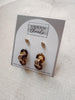 Pair of gold and brown earrings on a 'Urban Threads' branded card.