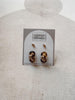 Pair of gold earrings on a card with 'Urban Threads' branding against a beige background