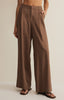 Brown wide-leg pants worn by a person on a beige background
