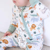 Baby wearing a sleep bag with animal print on a neutral background