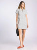 Woman wearing a black and white striped dress on a plain background