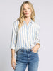 Woman wearing a striped shirt and jeans on a plain background