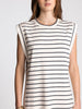 Woman wearing a sleeveless dress with black horizontal stripes on a plain background