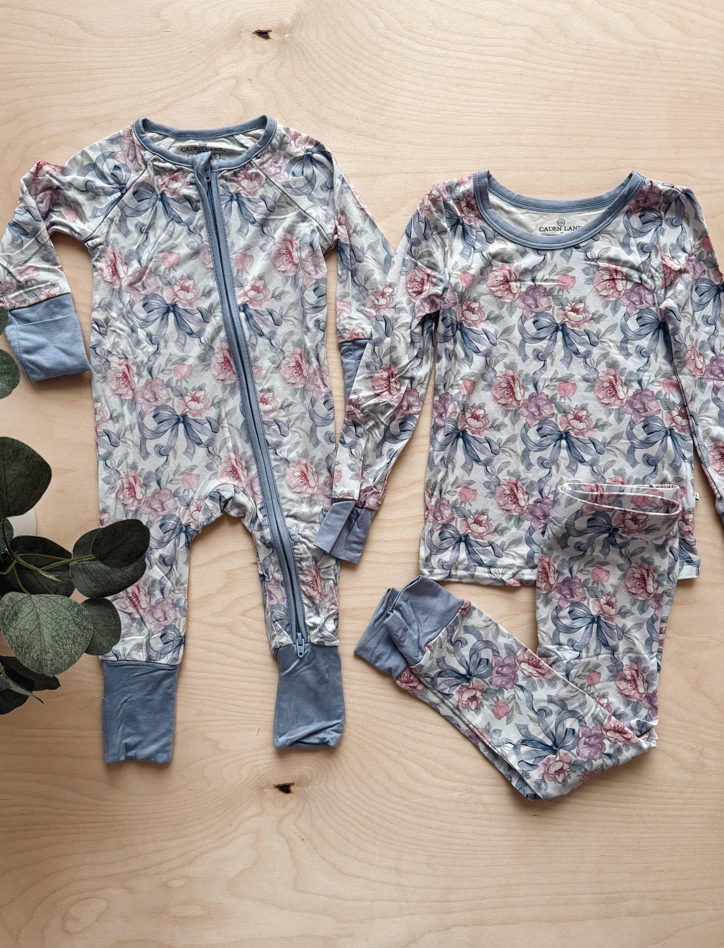 Floral-patterned baby outfit on a wooden surface