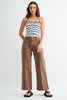 A woman modeling a white and navy blue horizontally striped camisole top paired with brown wide-leg cropped pants and black slide sandals, set against a plain light gray studio background.
