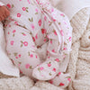 Baby in a floral outfit lying on a soft surface