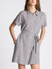 Woman wearing a black and white checkered dress on a plain background