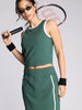 Woman in green athletic outfit holding a tennis racket on a light gray background