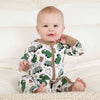 Baby wearing a onesie with green truck pattern on a white background