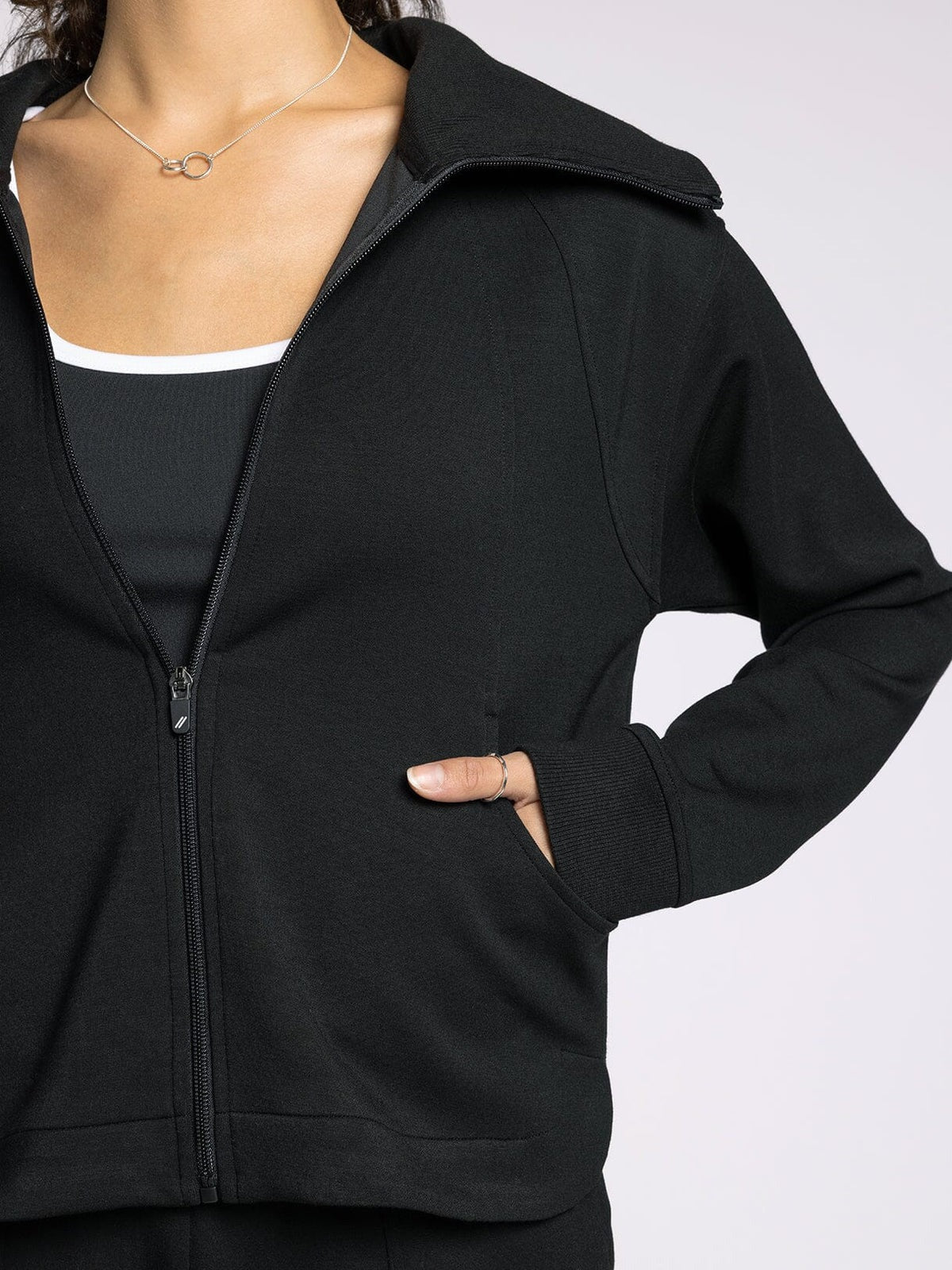 Black zip-up hoodie worn by a person on a white background